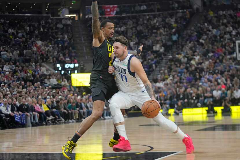 Utah Jazz forward John Collins, left, defends as Dallas Mavericks guard Luka Doncic drives...