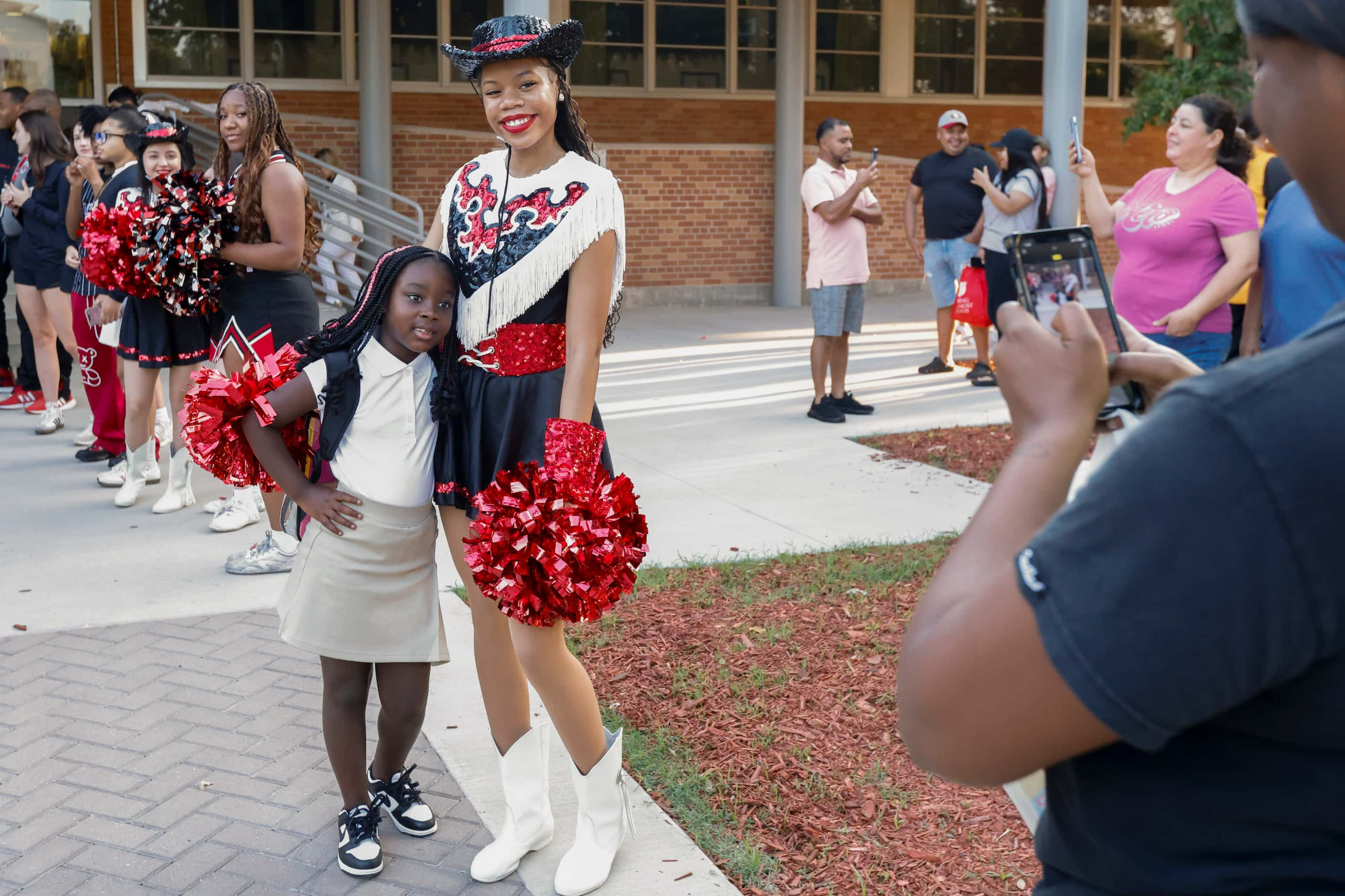 Delilah Harris, 5, poses for photo with Hillcrest High School Panader Dyani Dean, 16, before...