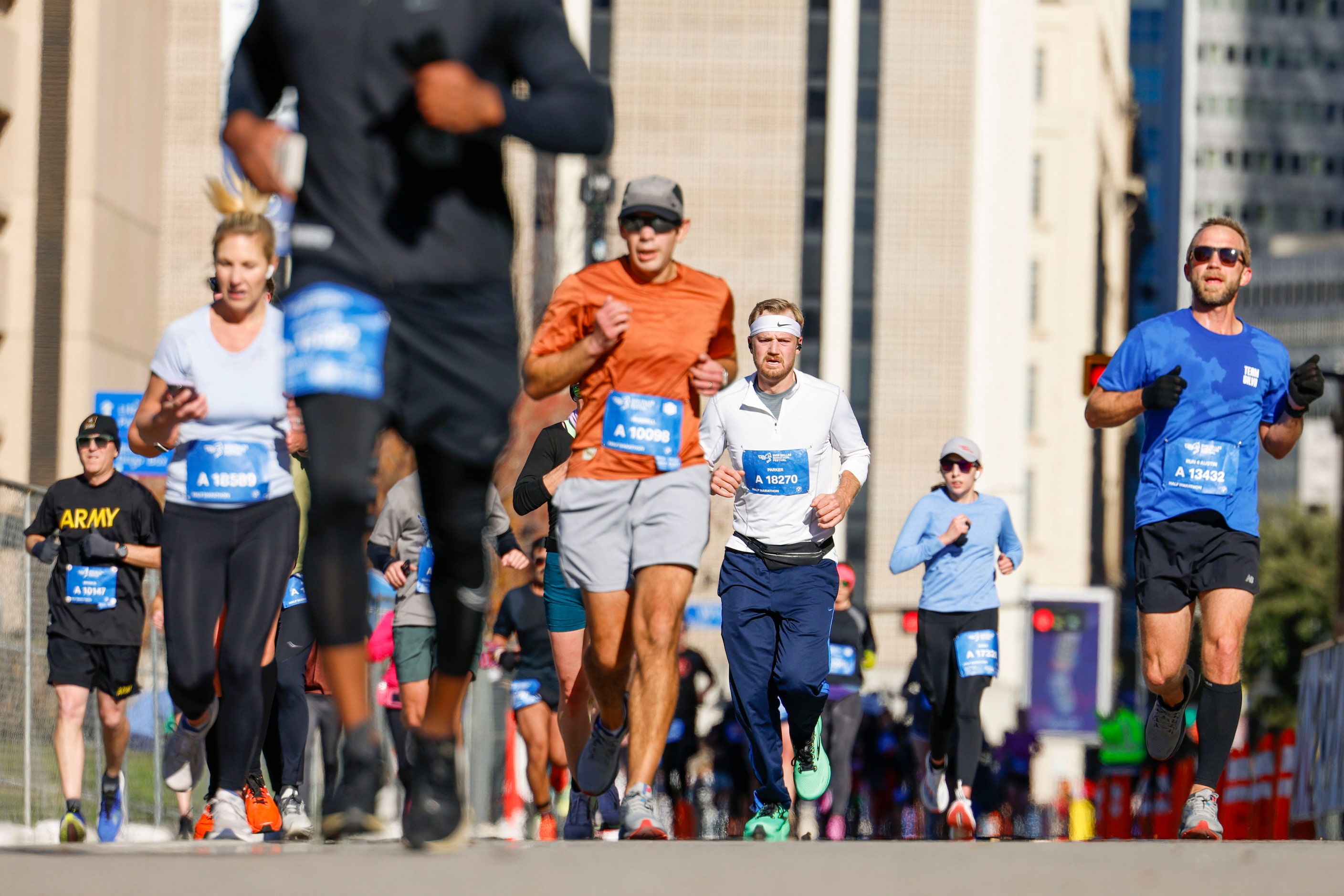 A runner reacts towards the camera as he including other run along South Ervay St. during...