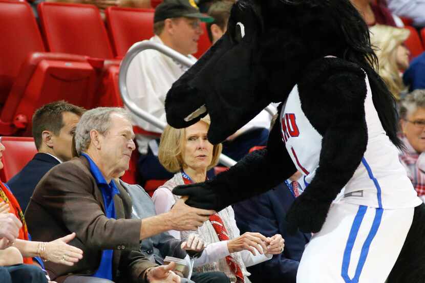 Southern Methodist Mustangs mascot Peruna shakes hands with former President George W. Bush...