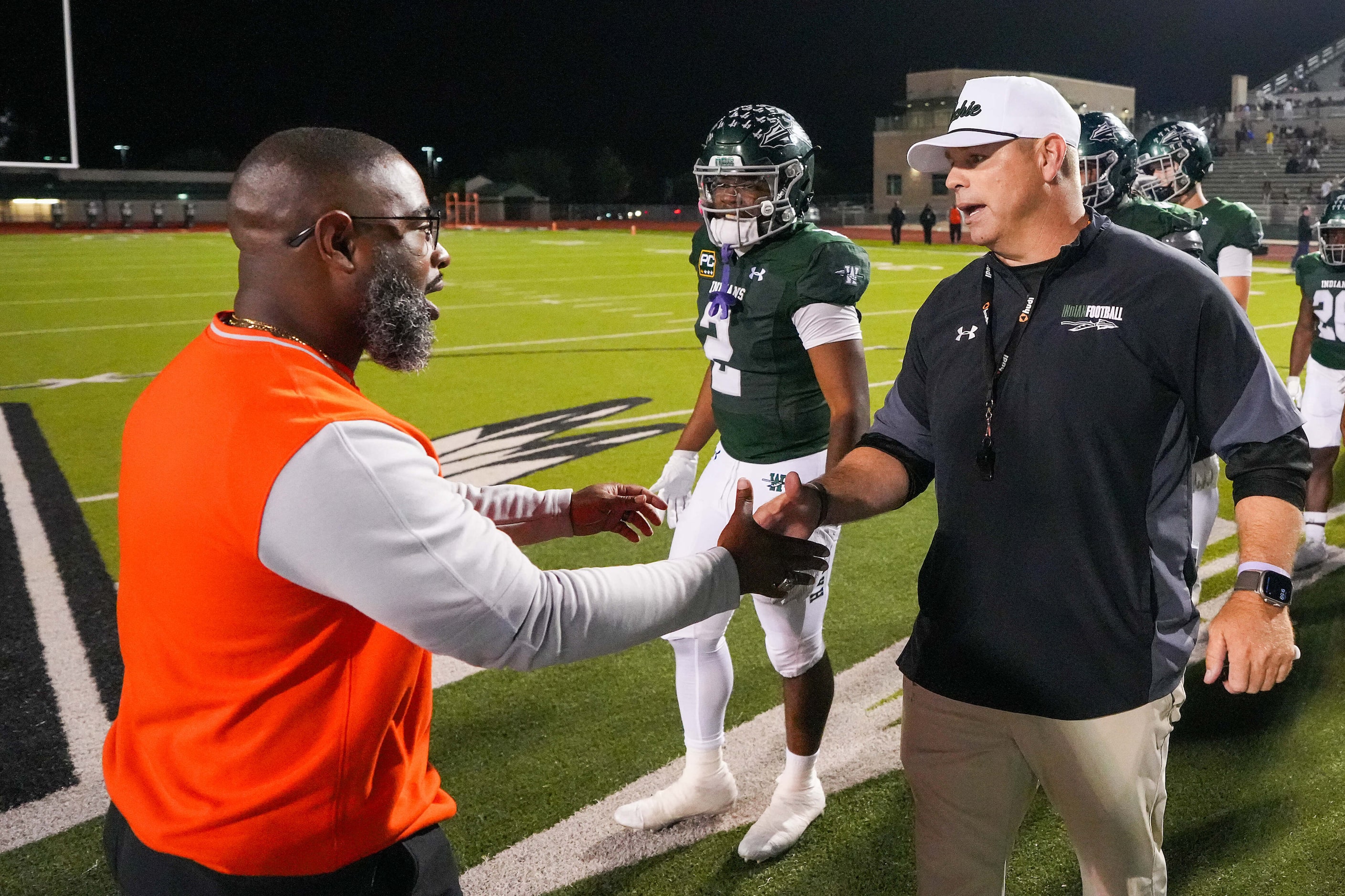 Waxahachie head coach Shane Tolleson (right) shakes hands with Lancaster head coach Leon...