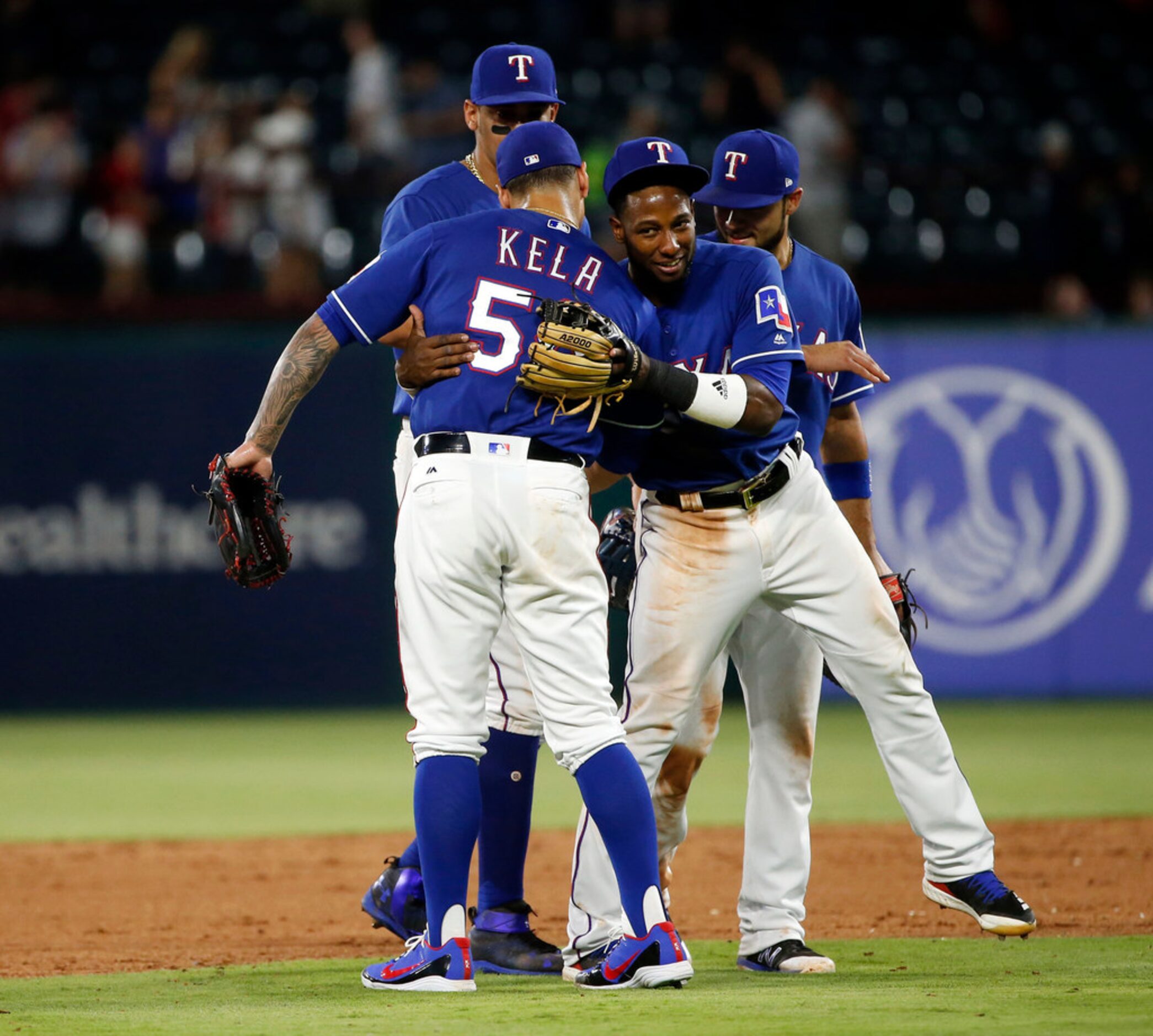 Texas Rangers relief pitcher Keone Kela (50) gets a hug from shortstop Jurickson Profar...