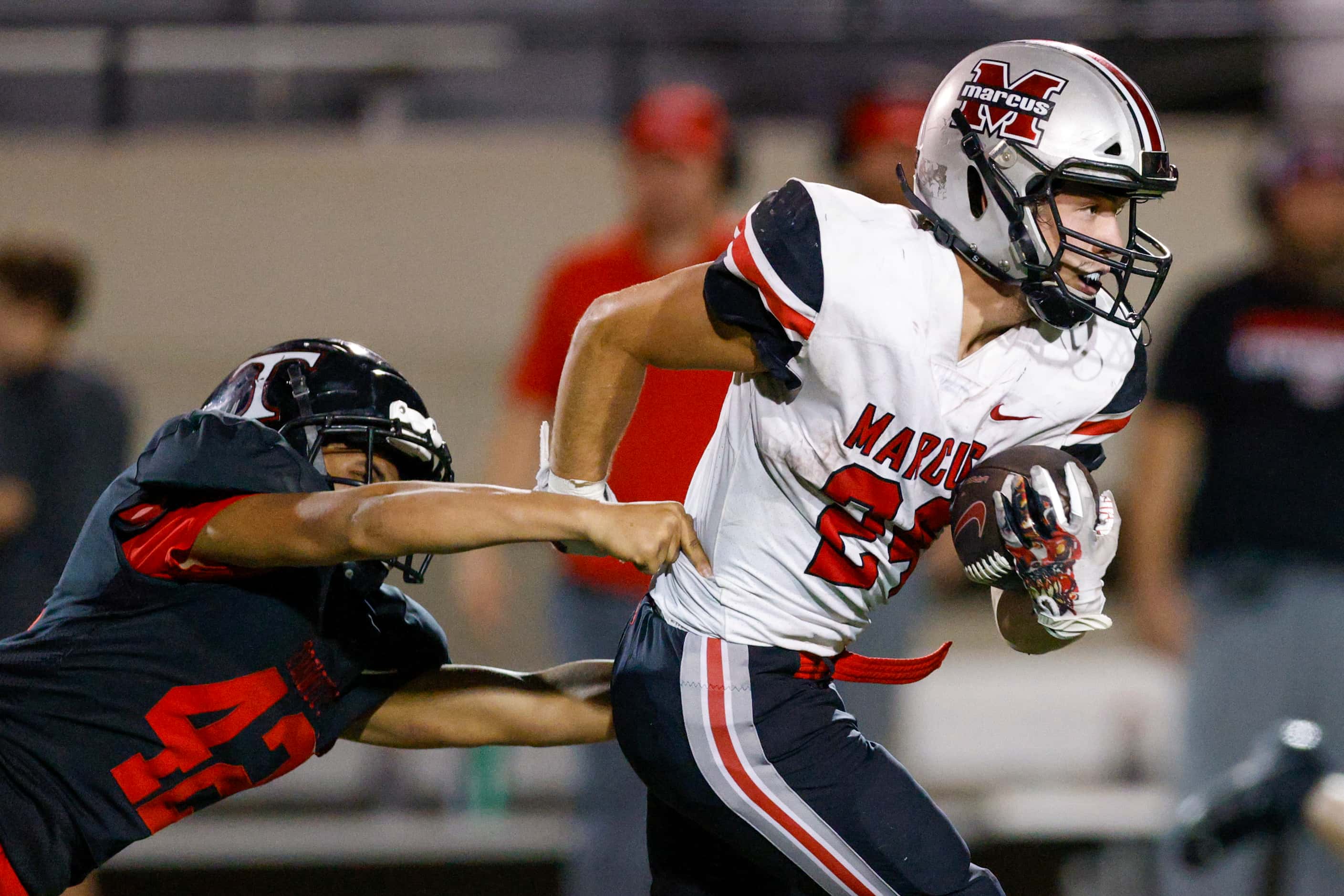 Flower Mound Marcus running back Isiah Keliikipi (24) slips a tackle from Euless Trinity...