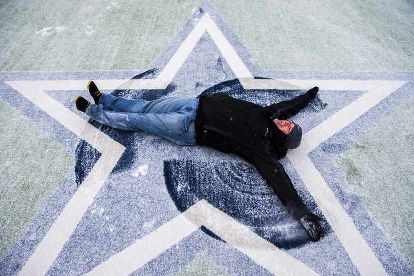 Bret Floyd of Friendswood, Texas makes snow angels on a novelty football field outside The...