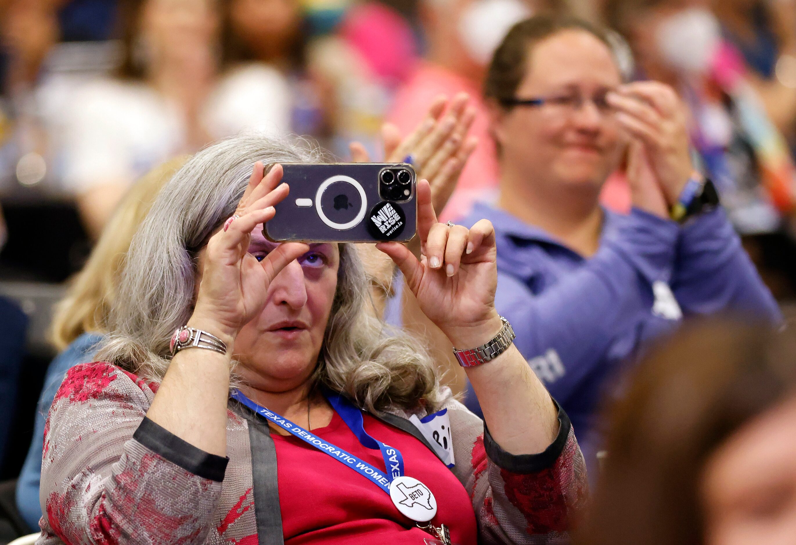 A woman records Texas Attorney General challenger Rochelle Garza speaking during the Lady...