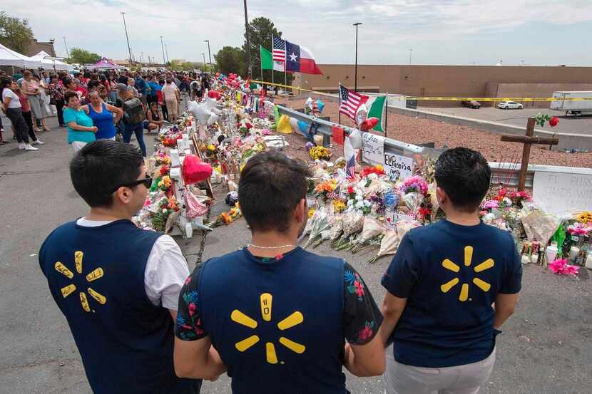 Walmart employees pay their respects at a makeshift memorial for the shooting victims, at...