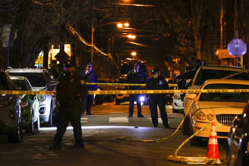 Philadelphia police officers investigate the fatal shooting of a Temple University police...