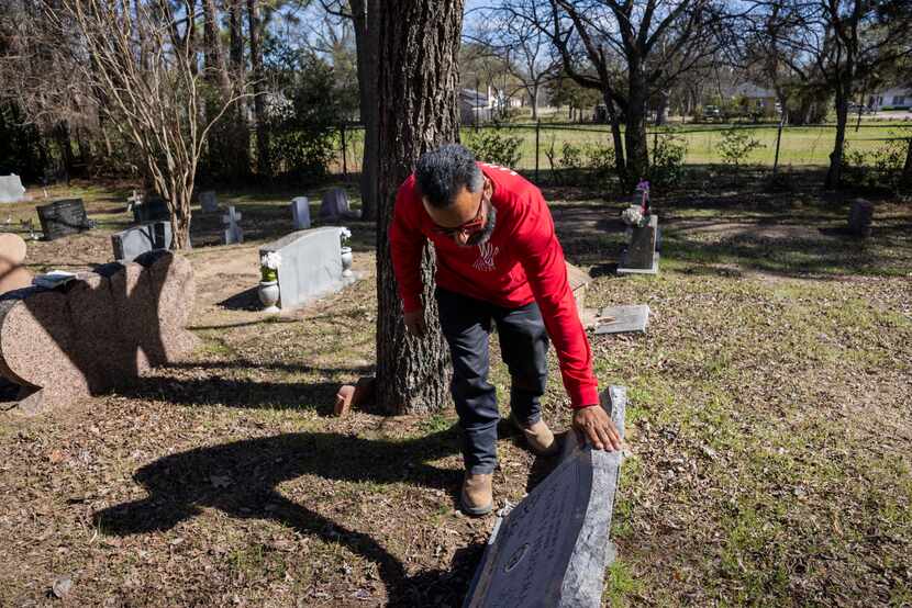 Rafael Rivera, Oakland Cemetery board secretary and volunteer, examines the headstone of his...