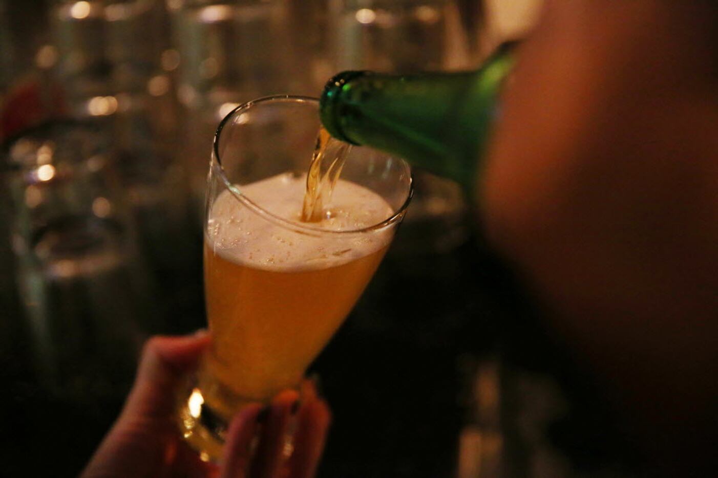 A bartender pours a beer during trivia night at the Holy Grail Pub in Plano.