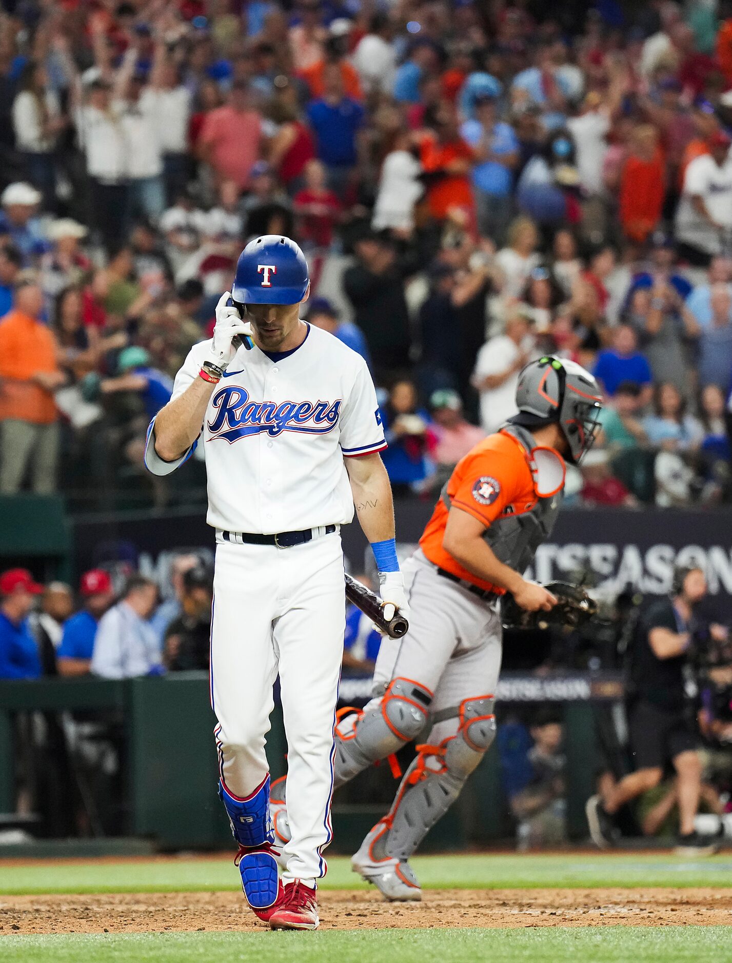 Texas Rangers left fielder Evan Carter walks off the field after striking out to end a loss...