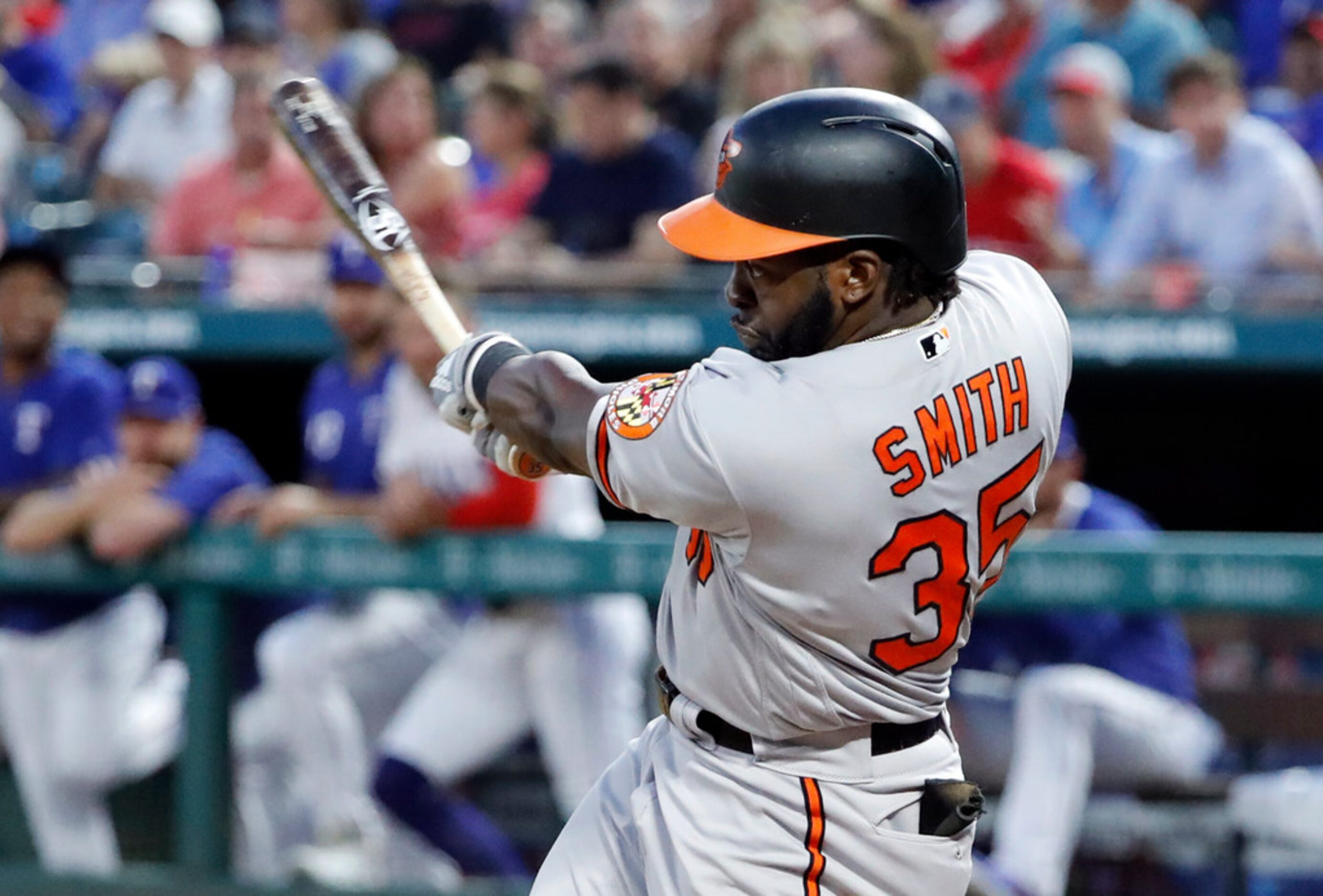 Baltimore Orioles' Dwight Smith Jr., follows through on a three-run double off Texas Rangers...