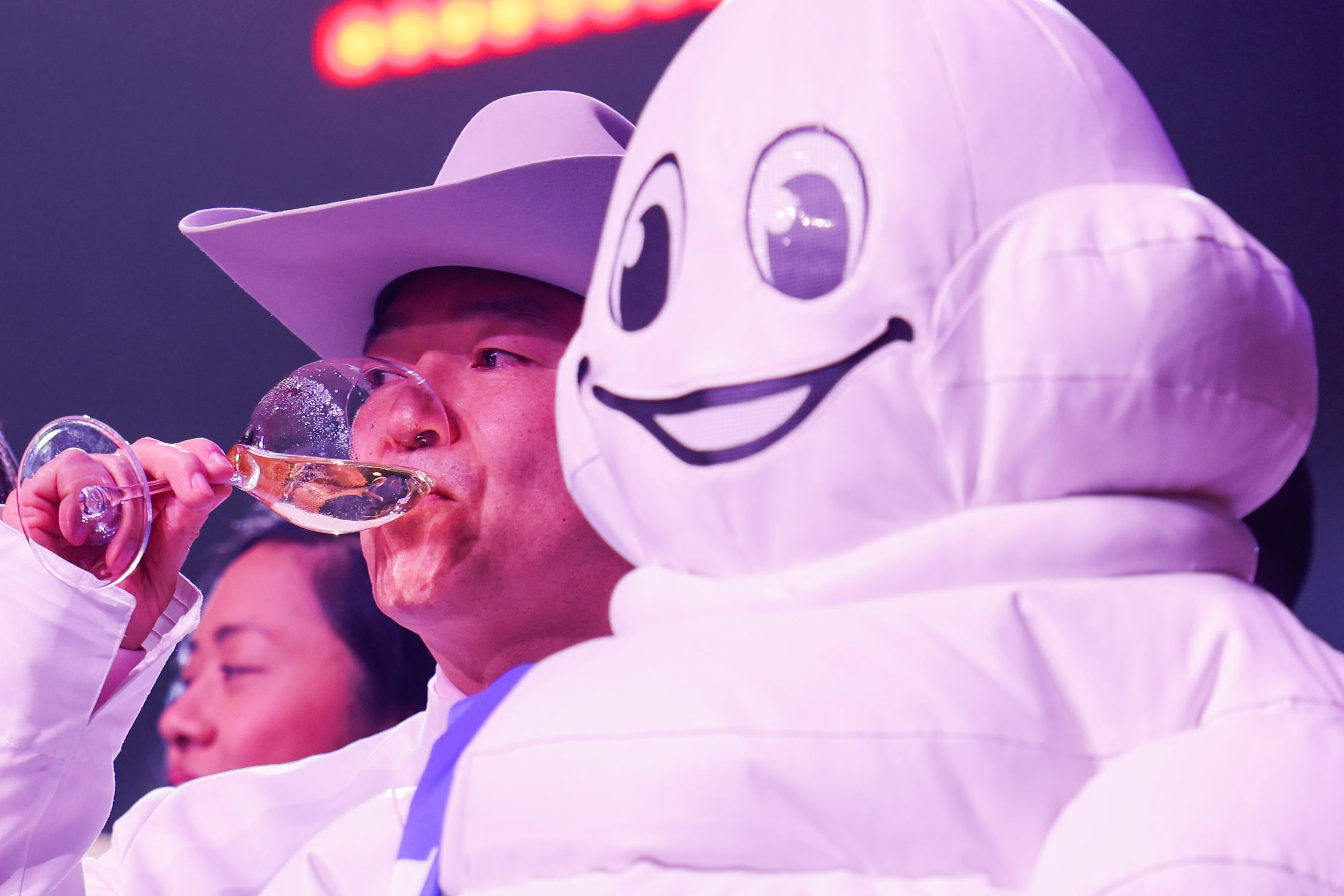 Chef Tatsuya Sekiguchi of Tatsu Dallas sips the champagne on the stage by the Michelin Man...