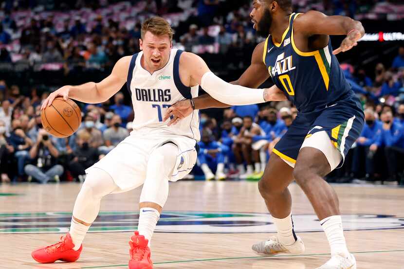 El jugador de los Mavericks de Dallas, Luka Doncic (izq), intenta quitarse la marca del...