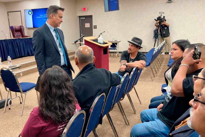 El senador estatal de Texas Roland Gutierrez, de pie, habla con familiares de niños muertos...