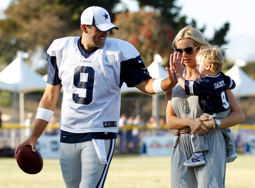 Dallas Cowboys quarterback Tony Romo (9) plays with his son Hawkins Romo, 1, as his wife...