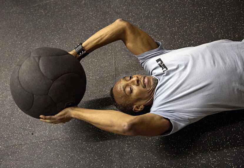 
Bruce Boyd does sit-ups with a medicine ball during a strength and conditioning class at...