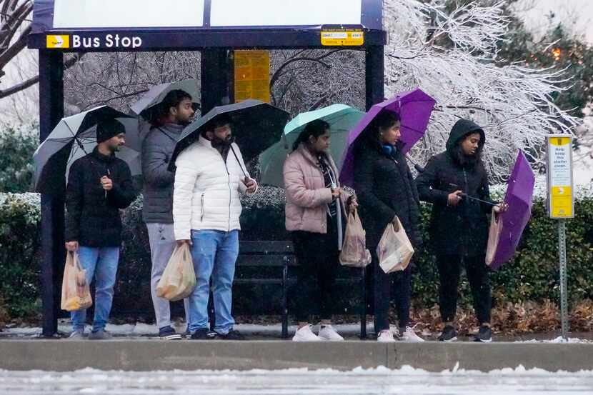 People waited at a DART bus shelter on Renner Road in a cold rain on Thursday, Feb. 2, 2023,...