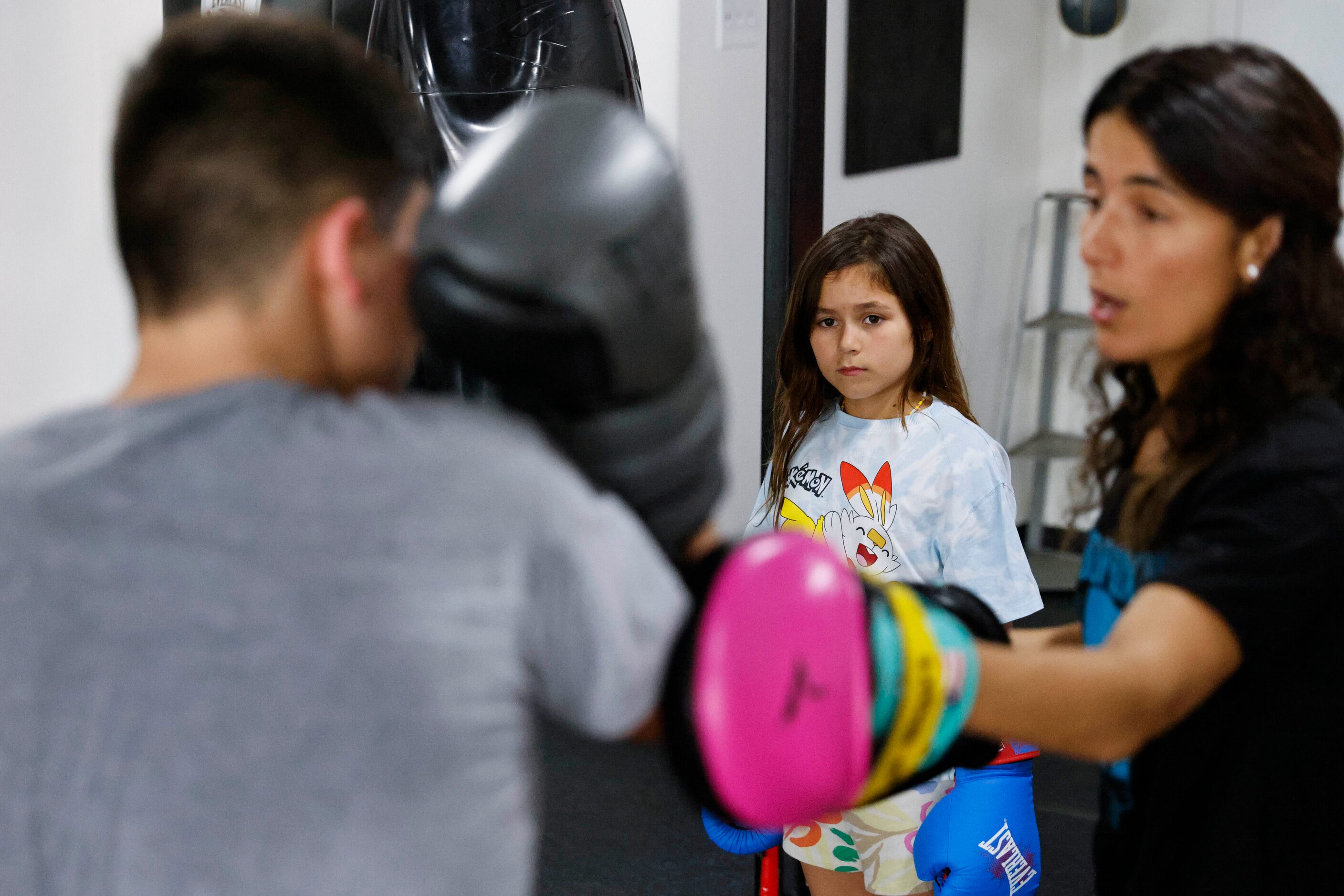 Amanda Alvarez, a salsa teacher and boxing lover, trains Eduardo Soto (left) as her daughter...