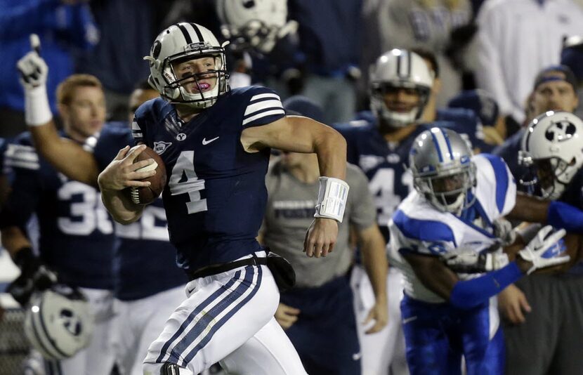 FILE - In this Sept. 27, 2013, file photo, BYU quarterback Taysom Hill (4) scores as he...