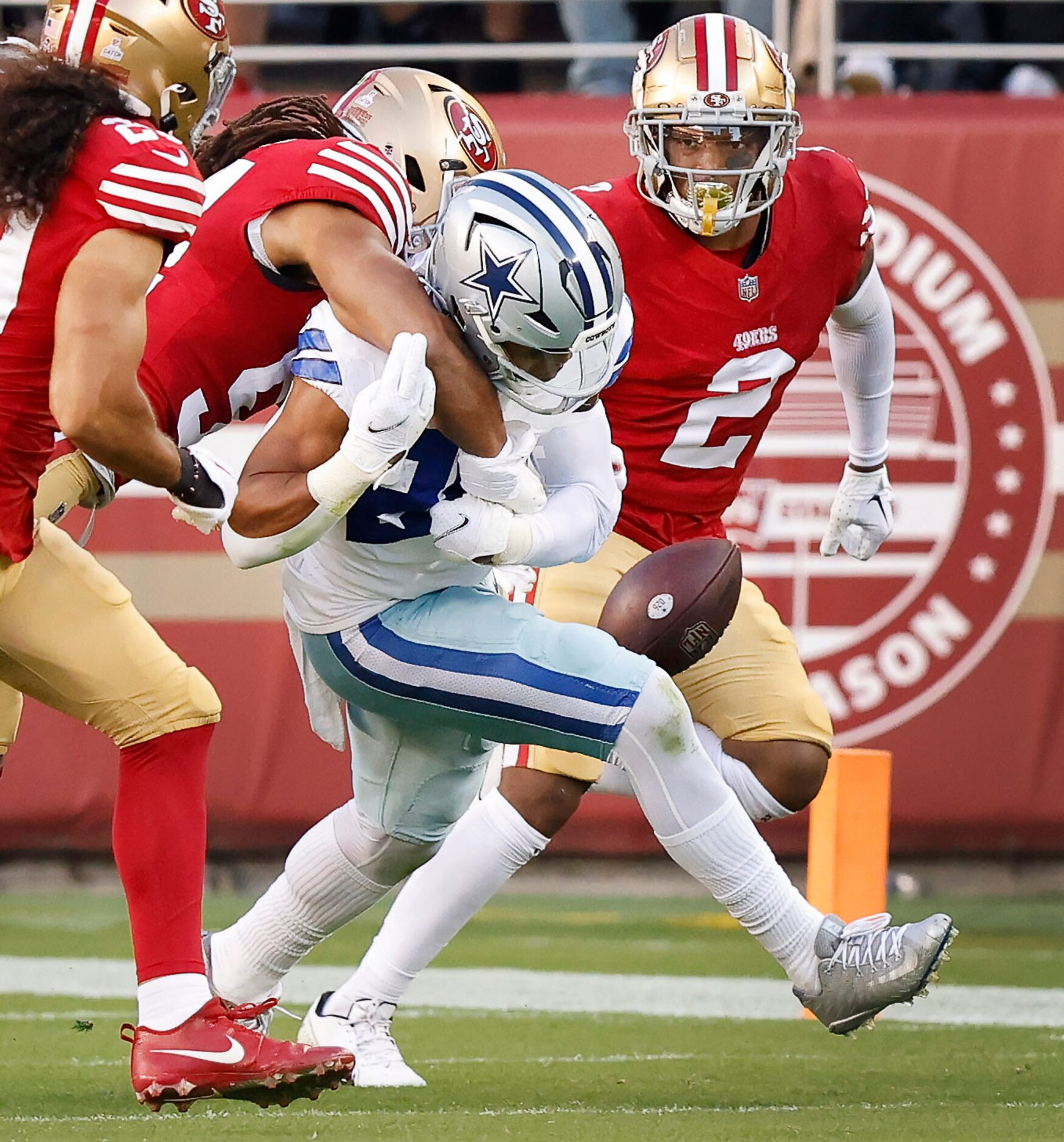 Dallas Cowboys running back Tony Pollard (20) fumbles the ball after being hit by San...