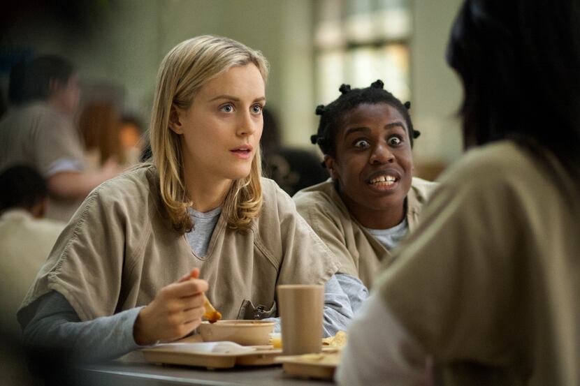 FILE - This image released by Netflix shows Taylor Schilling, left, and Uzo Aduba in a scene...