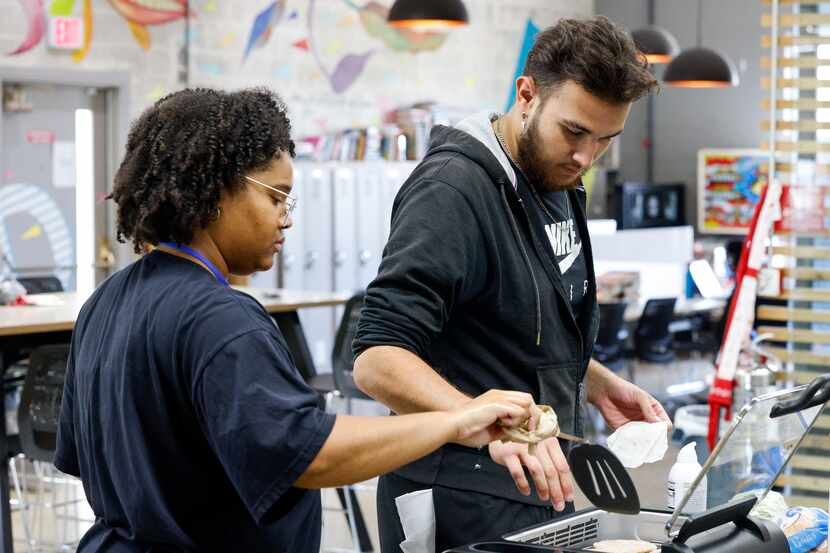 After8toEducate intern Raegan Freemon and Noel Zabel, 21, cook turkey burgers during a...