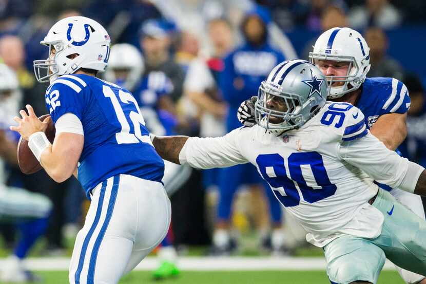 Dallas Cowboys defensive end Demarcus Lawrence (90) gets ahold of Indianapolis Colts...