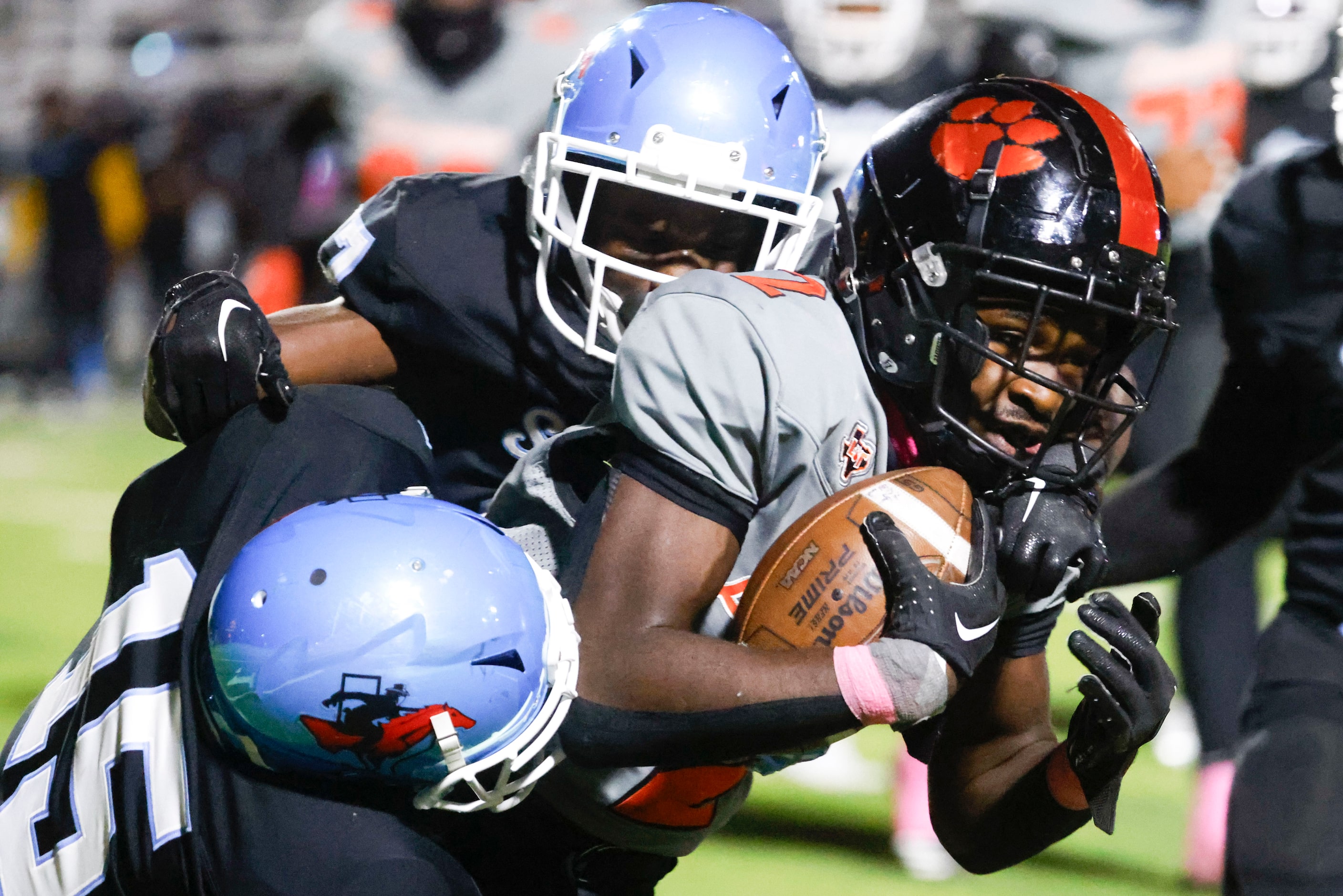 Lancaster High’s Izayah Lee (center) is brought down by Skyline High’s William Davis (left)...