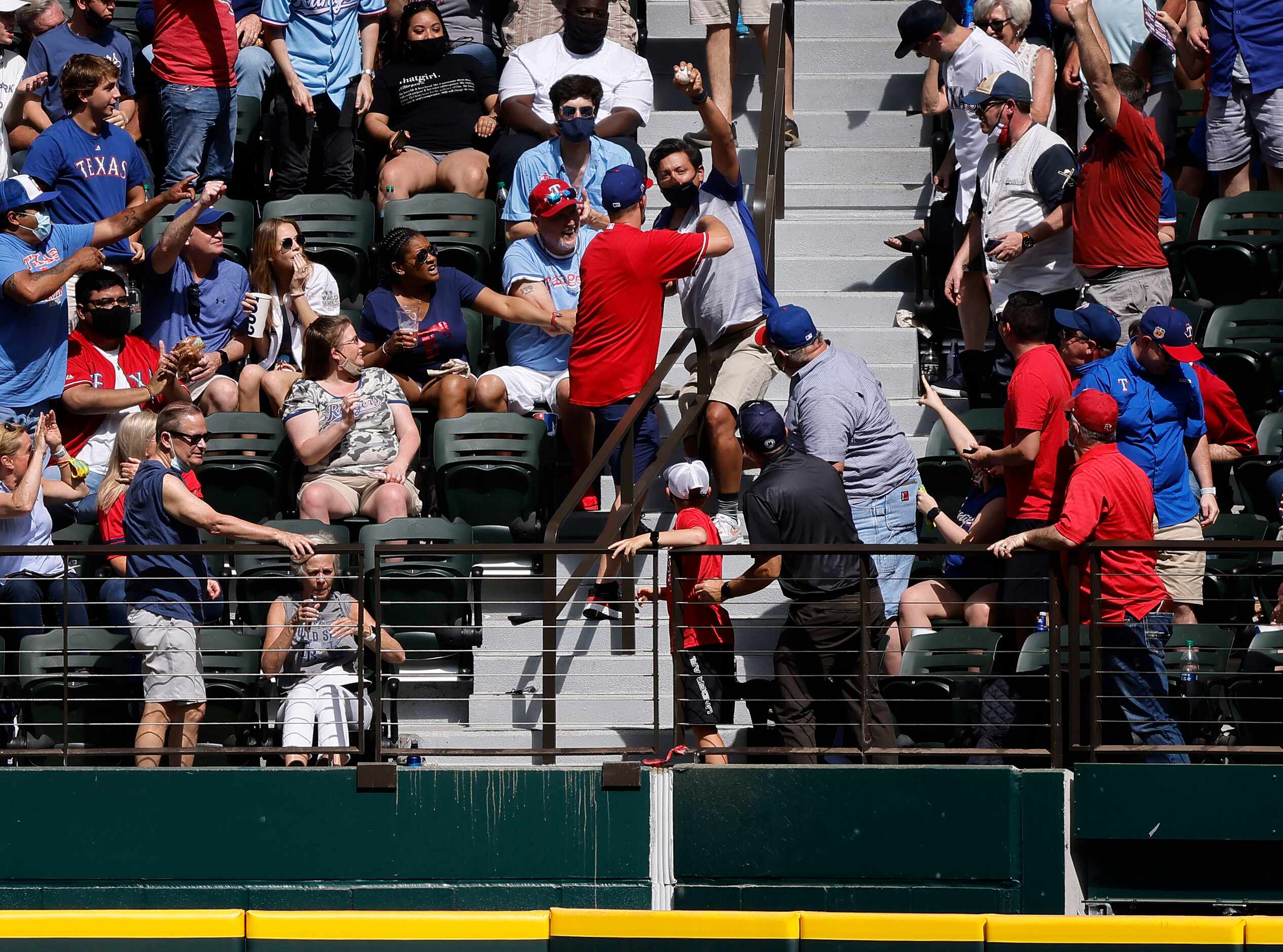 A Texas Rangers fan catches a Toronto Blue Jays home run ball in right field during Opening...