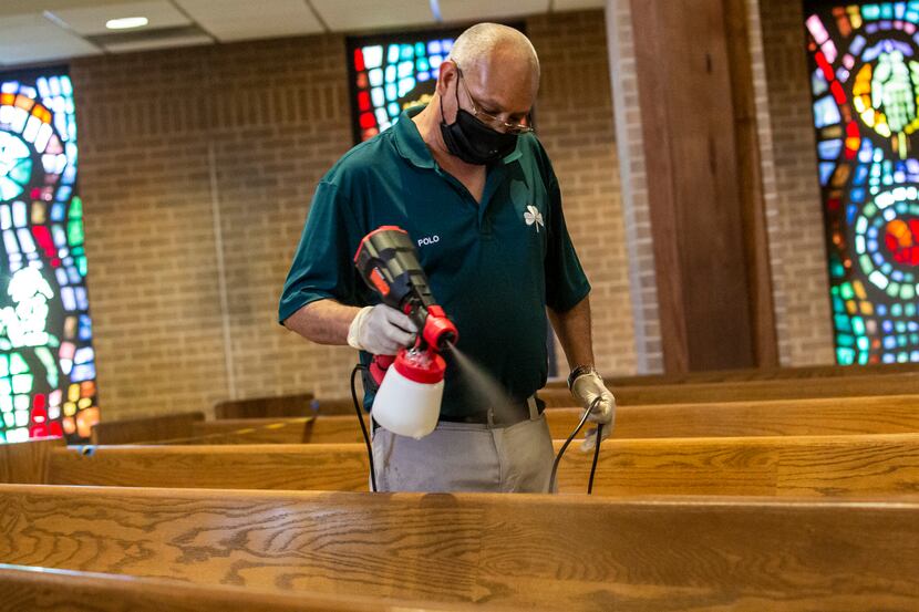 Polo Herrera sprays a sanitized on pews at the St. Patrick Catholic Church in the Lake...