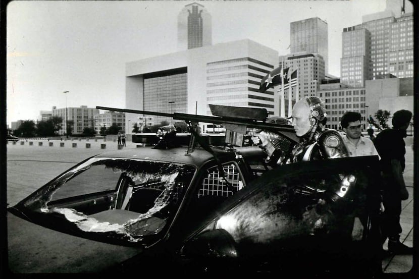 The Dallas skyline looms behind actor Peter Weller during a filming of RoboCop outside...