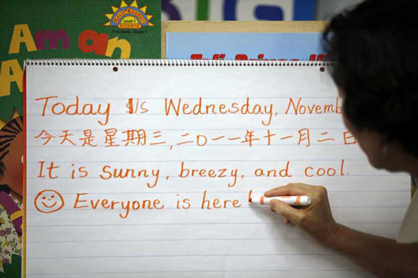 Donna Lam writes words in English and Chinese during a bilingual pre-kindergarten class at...