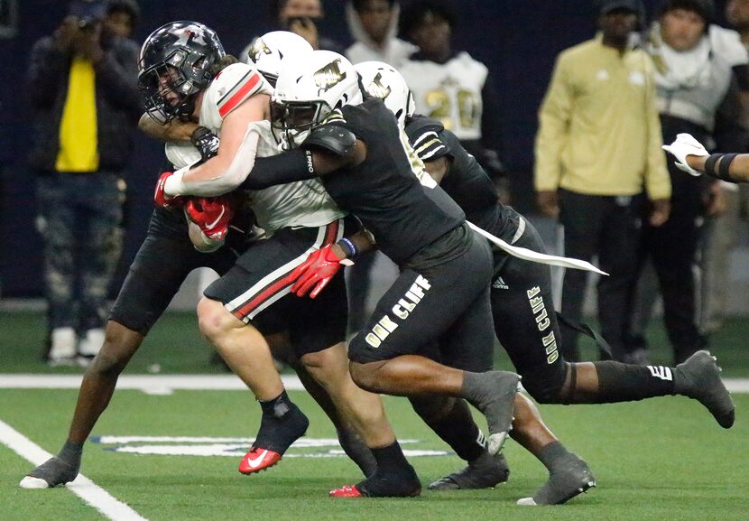 Lovejoy High School quarterback Payton Pierce (7) carries a host of South Oak Cliff High...