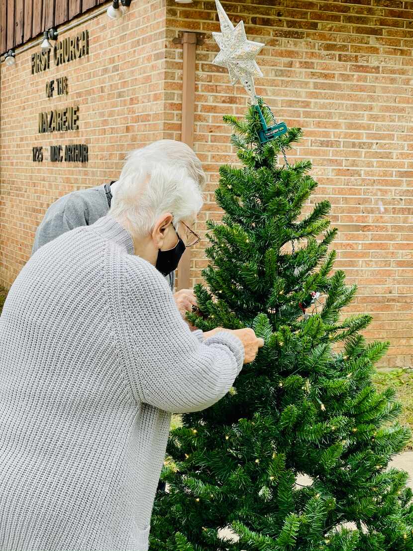 Visitors hang ornaments from trees outside Irving First Church of the Nazarene.