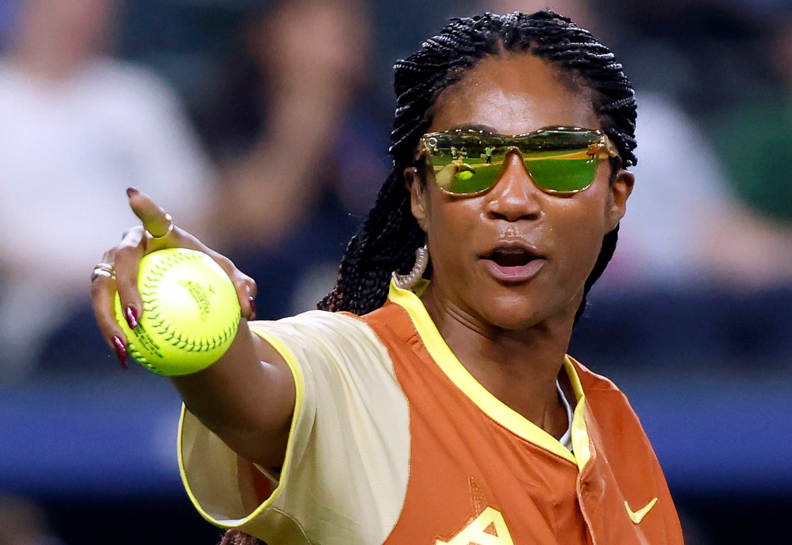 Comedian Tiffany Haddish points to the dugout as she pitches during the first inning of the...