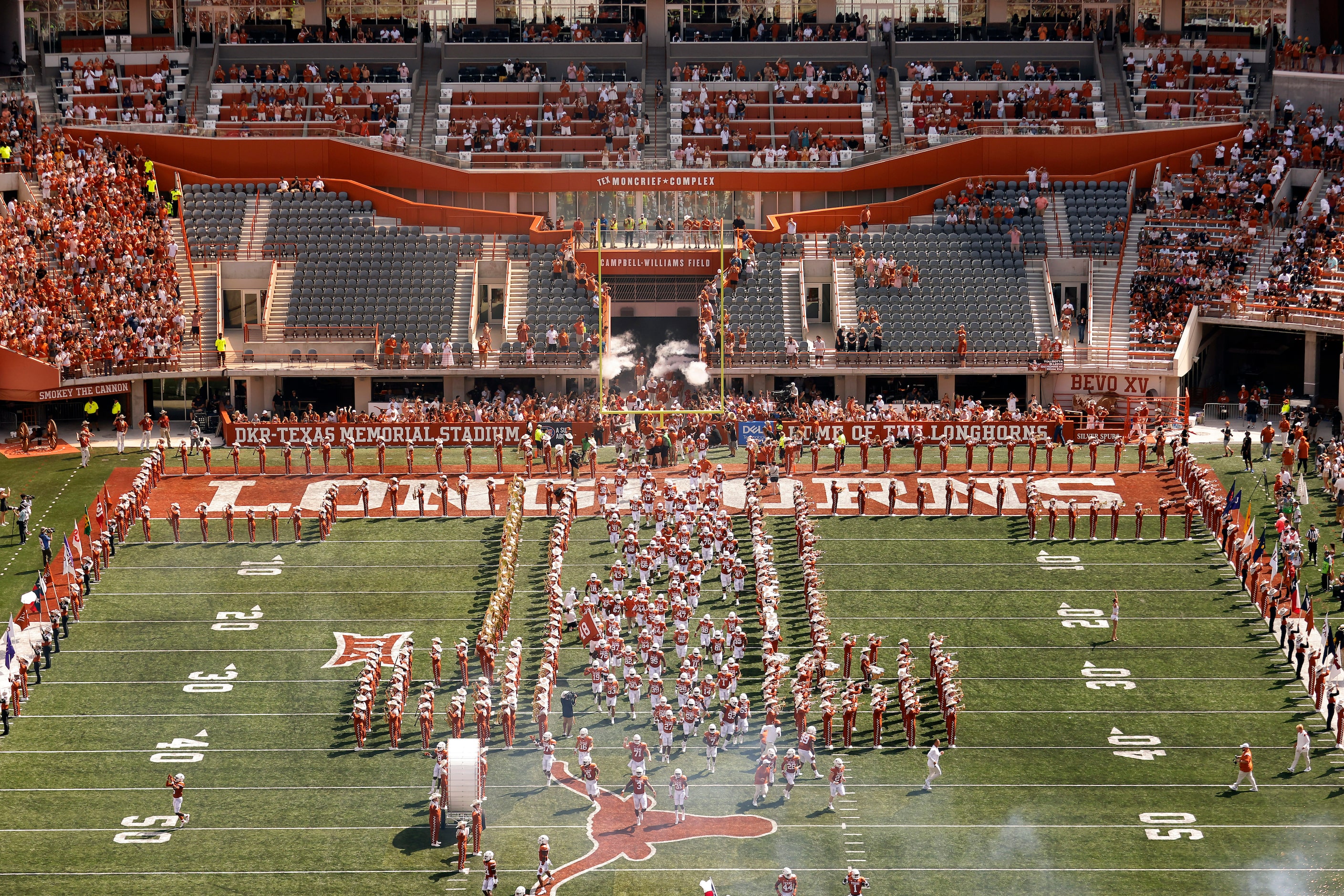 The Texas Longhorns football team sprints down the middle of the field as they introduced to...