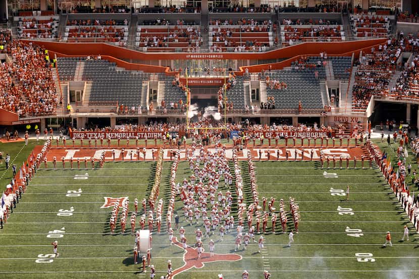 The Texas Longhorns football team sprints down the middle of the field as they introduced to...