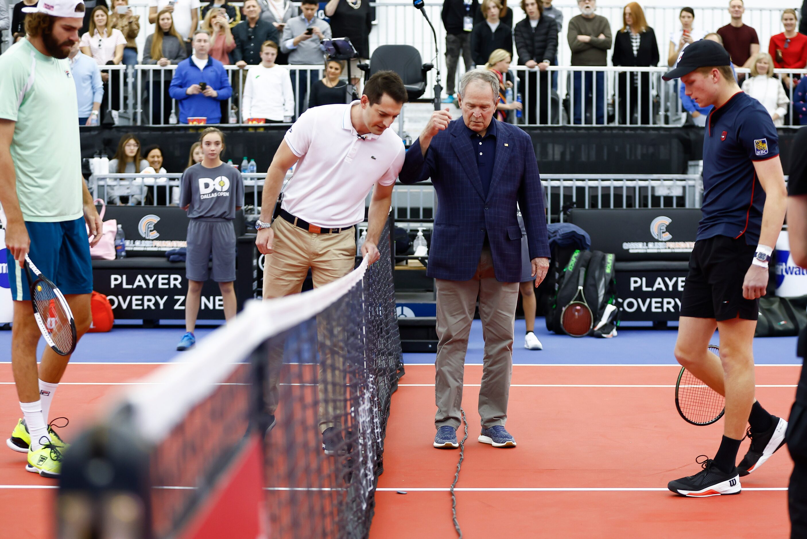 Former President George W. Bush, center right, tosses a coin before the start of the finals...