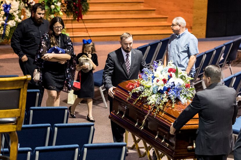 Shannan Claussen holds a flag as she follows her son Christian Riley Garcia's casket from...