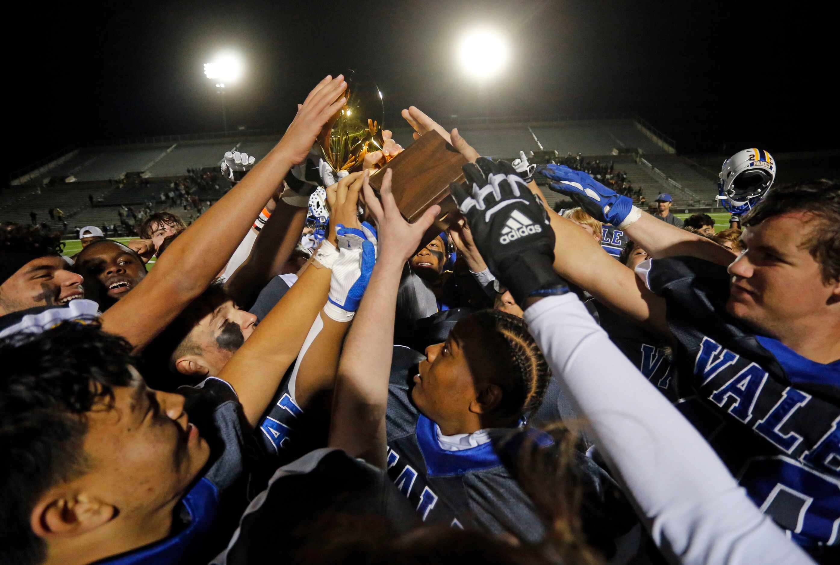 Sunnyvale players reach in to touch the game trophy, as they celebrate at the end of their...