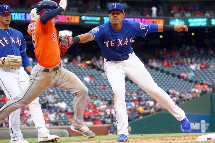 Ronald Guzman (11) of the Texas Rangers tags out Myles Straw (26) of the Houston Astros in...