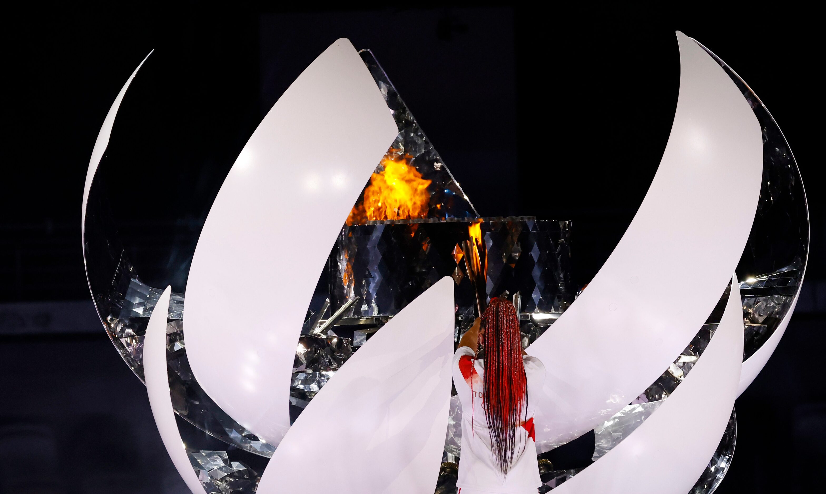 Naomi Osaka lights the Olympic cauldron during the opening ceremony for the postponed 2020...