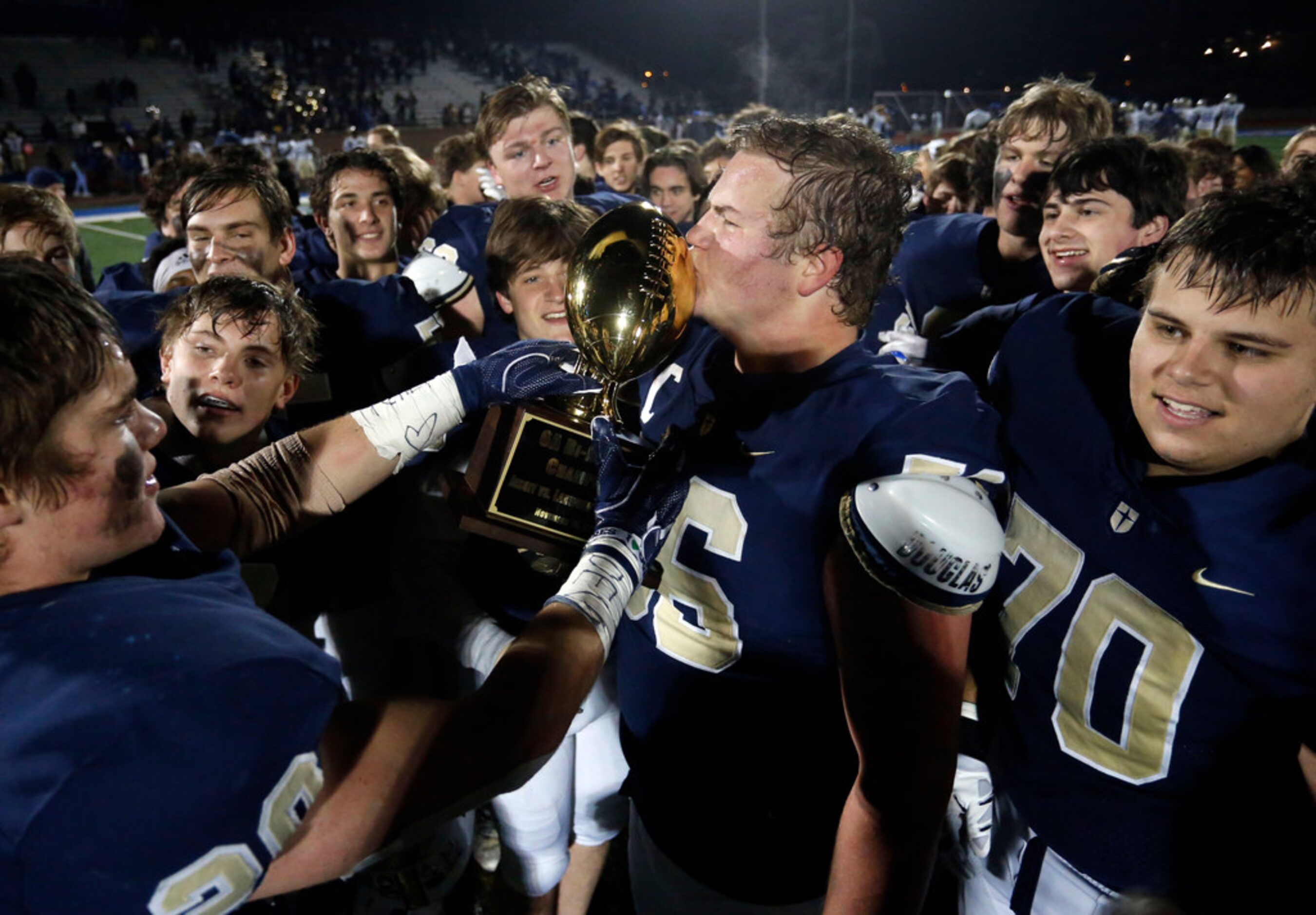 Jesuit's Branson Hickman (56) kisses the game trophy after Jesuit's 45-14 win over Garland...