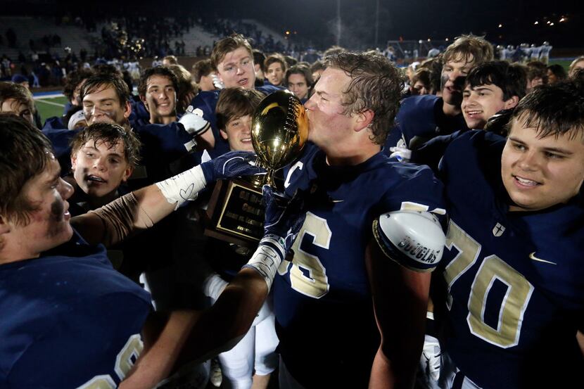 Jesuit's Branson Hickman (56) kisses the game trophy after Jesuit's 45-14 win over Garland...