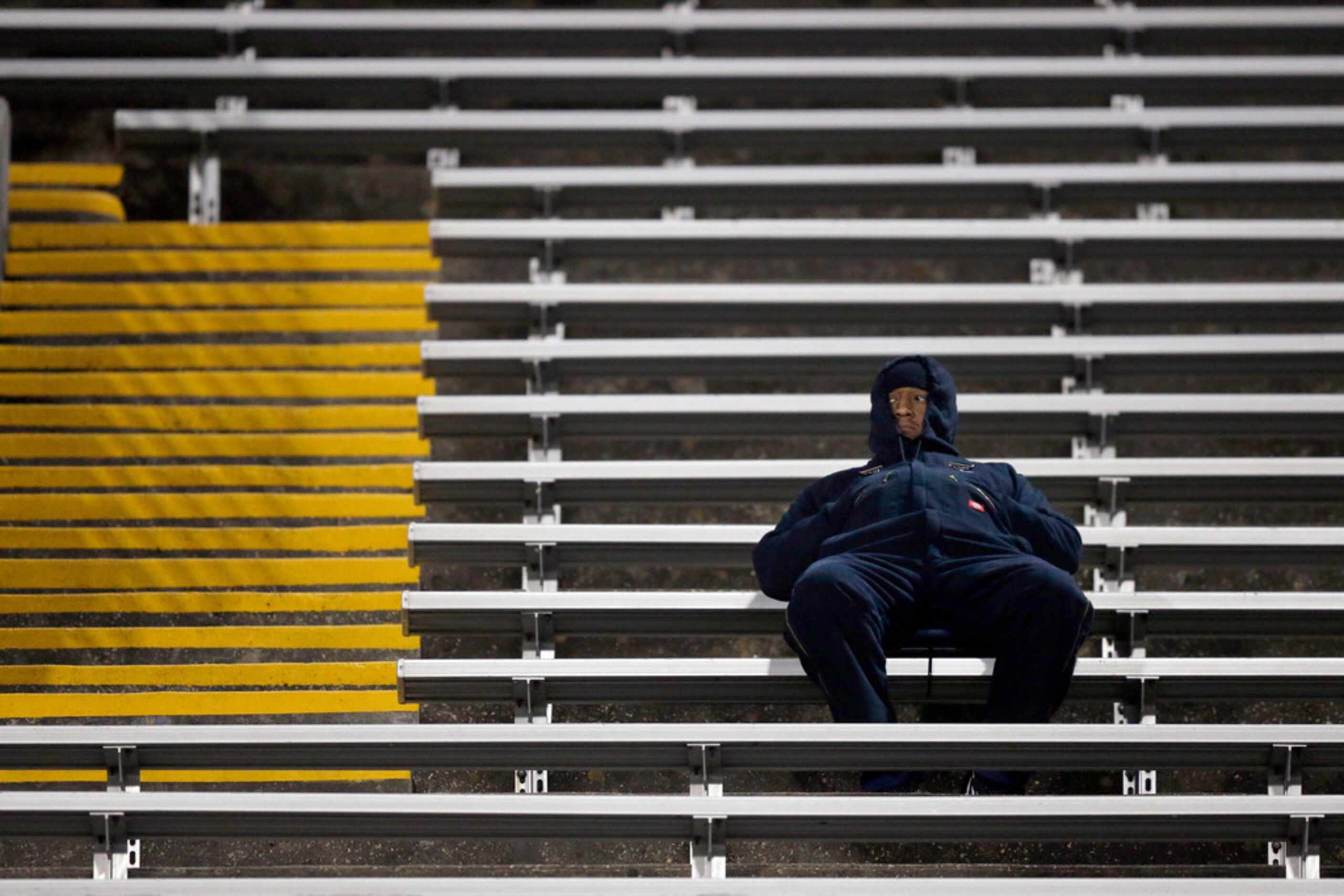 A bundled up Martin Warrior football fan watches the game against Bowie at Maverick Stadium...
