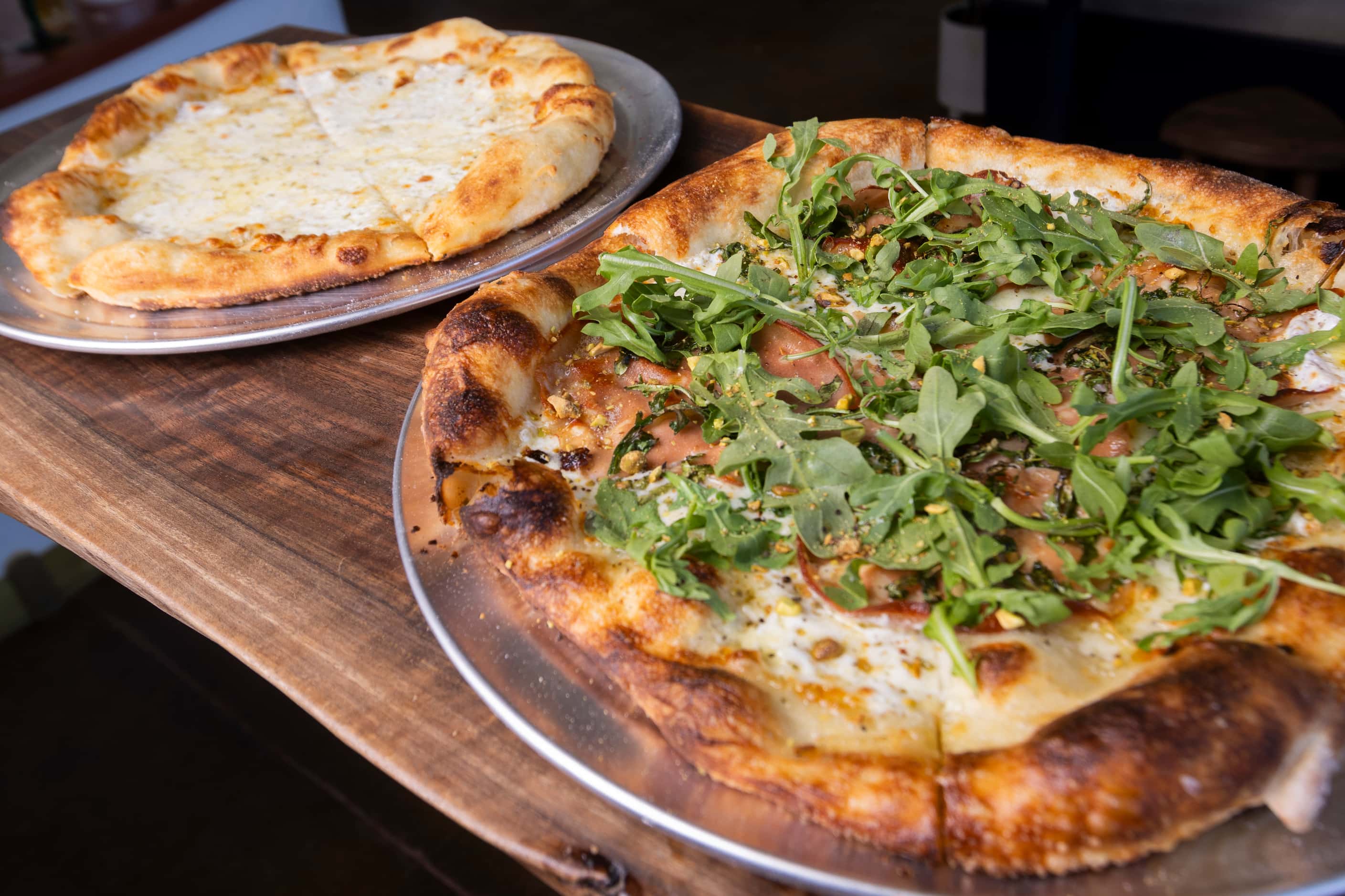 (From left) The White Sauce and Mortadella pizzas served at the Wriggly Tin, a new bar near...
