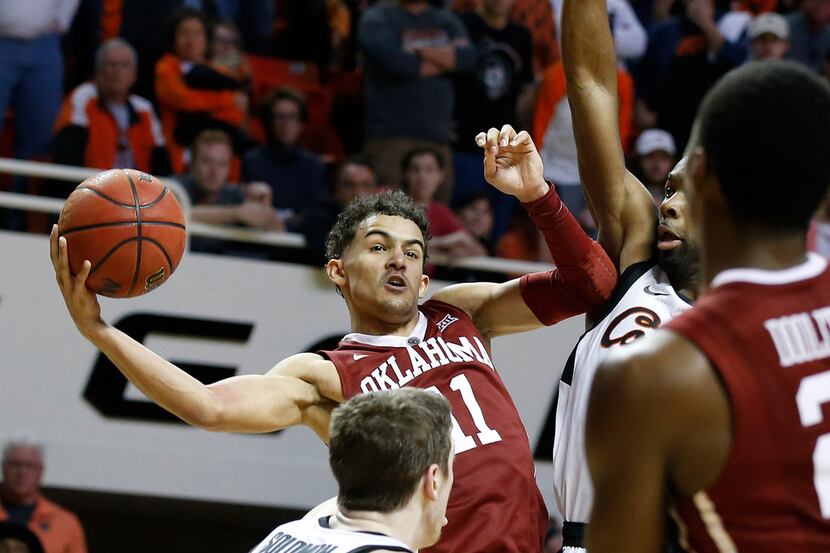Oklahoma guard Trae Young (11) is fouled by Oklahoma State guard Tavarius Shine, right, in...