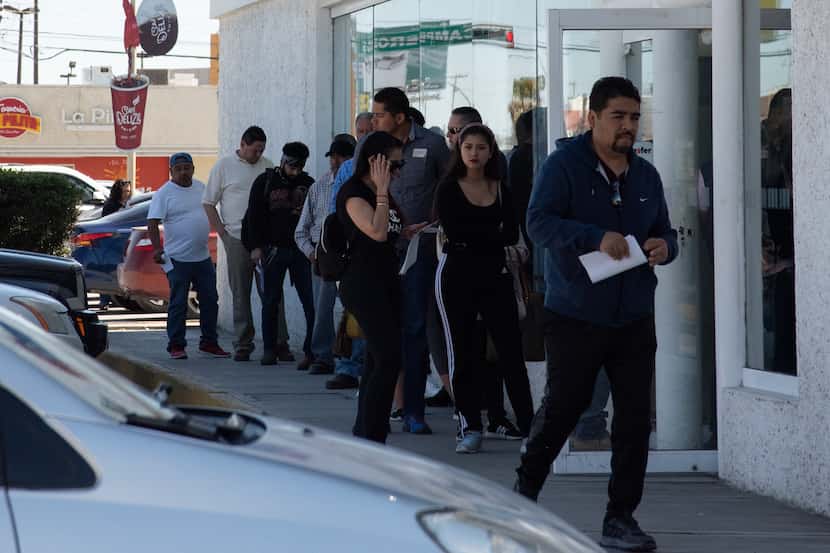 People line up to use an ATM in Ciudad Juarez, Mexico, March 25,2020. Unlike in the...