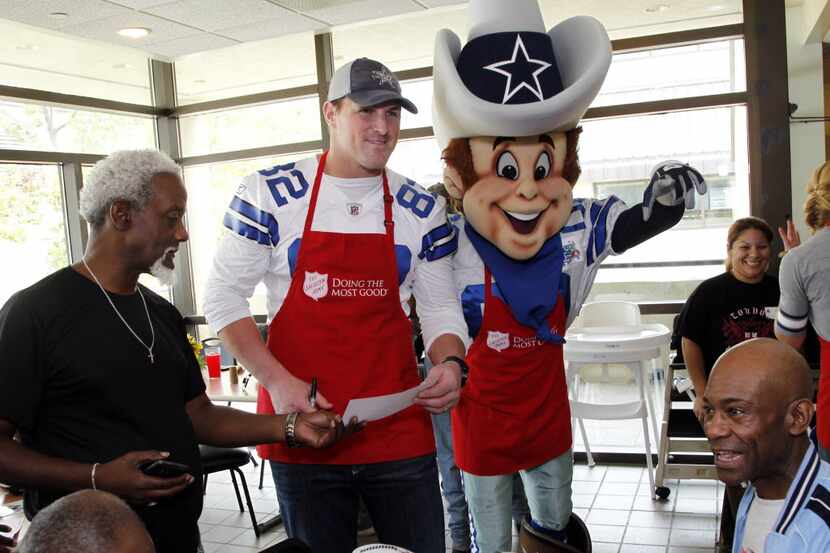 Jason Witten is backed up by team mascot Rowdy as he signs autographs after he and 11 of his...