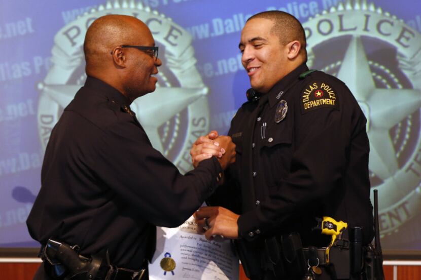 Dallas Police Chief David Brown (left) congratulated Officer Ryan Mabry, one of three...